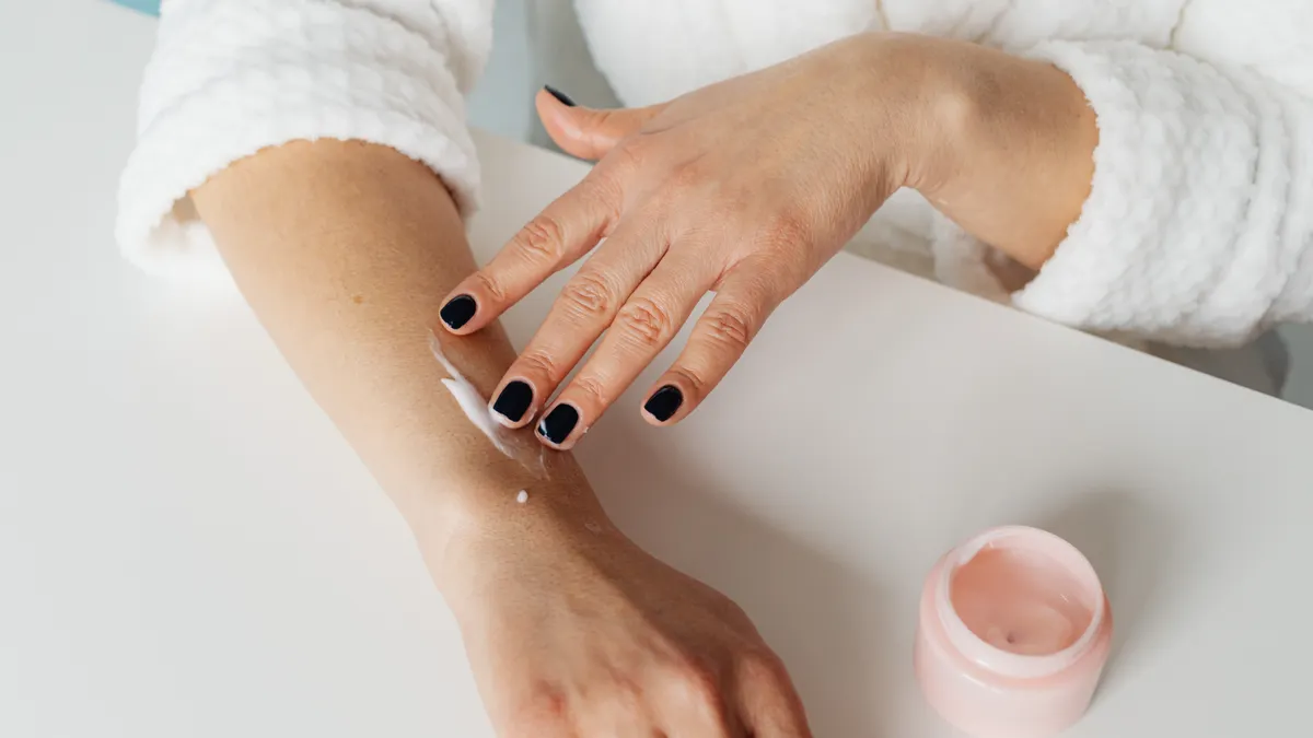 How to apply natural deodorant for best results Hands applying cream from an open jar
