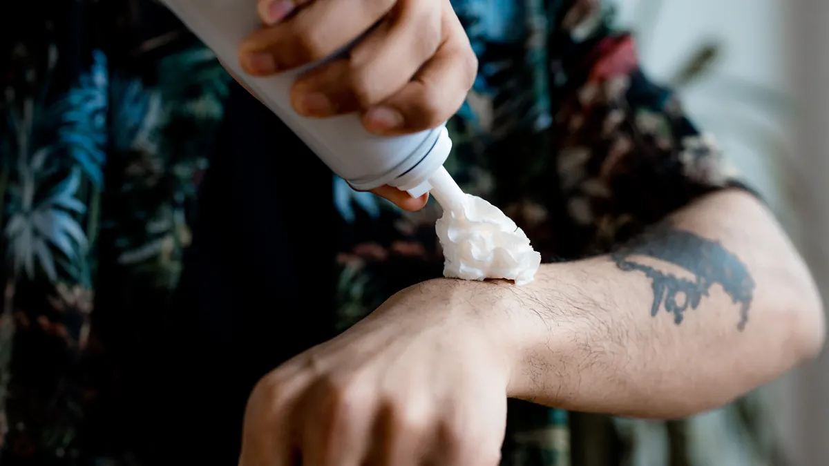 How to apply natural deodorant for best results Squeezing cream from a tube onto skin