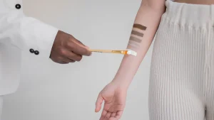 Person applying a swatch to inner forearm for a skin test