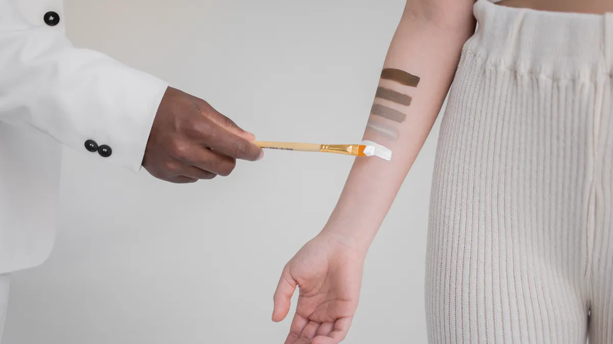 Person applying a swatch to inner forearm for a skin test